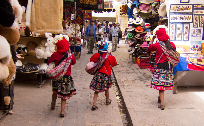 Sacred Valley Pisac Market girls walking with baby llamas